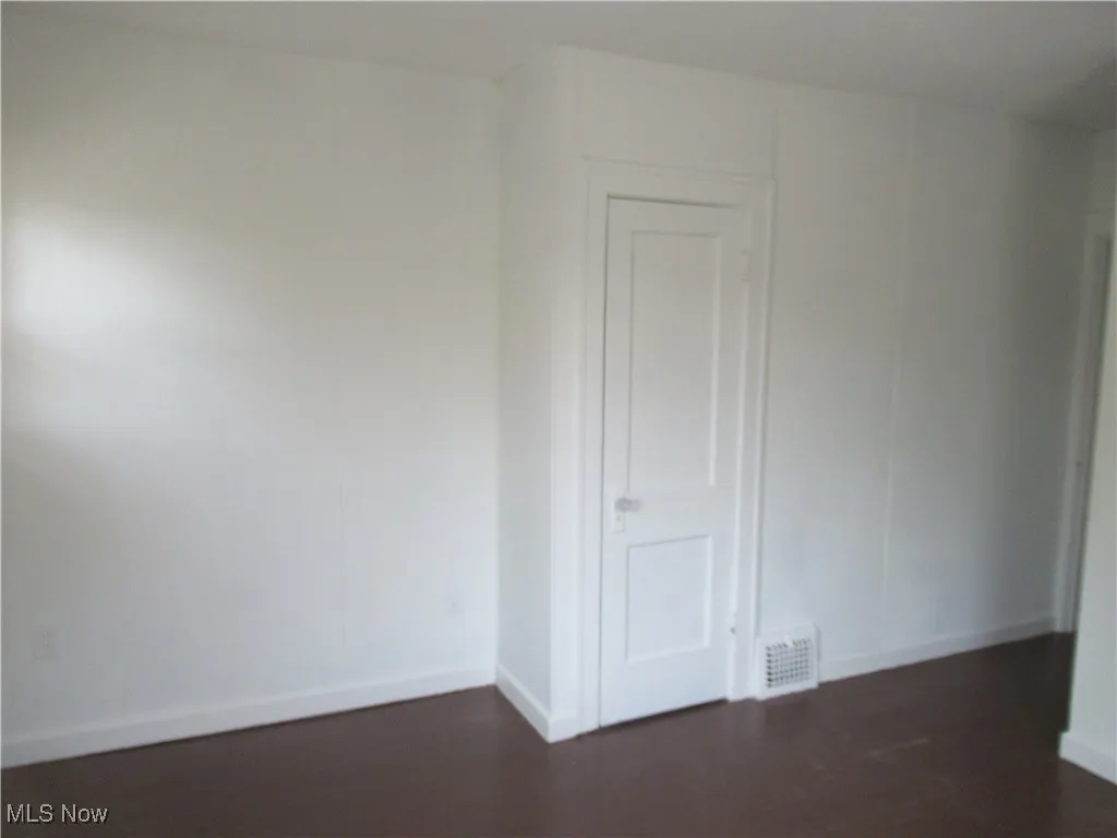 Empty room featuring dark wood-style flooring
