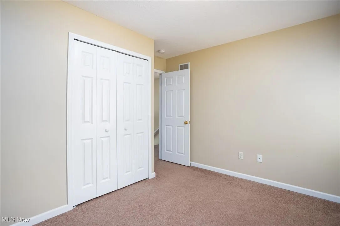 Unfurnished bedroom with carpet flooring and a closet