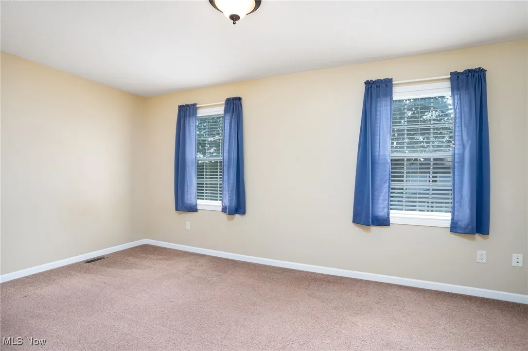 Carpeted empty room featuring baseboards