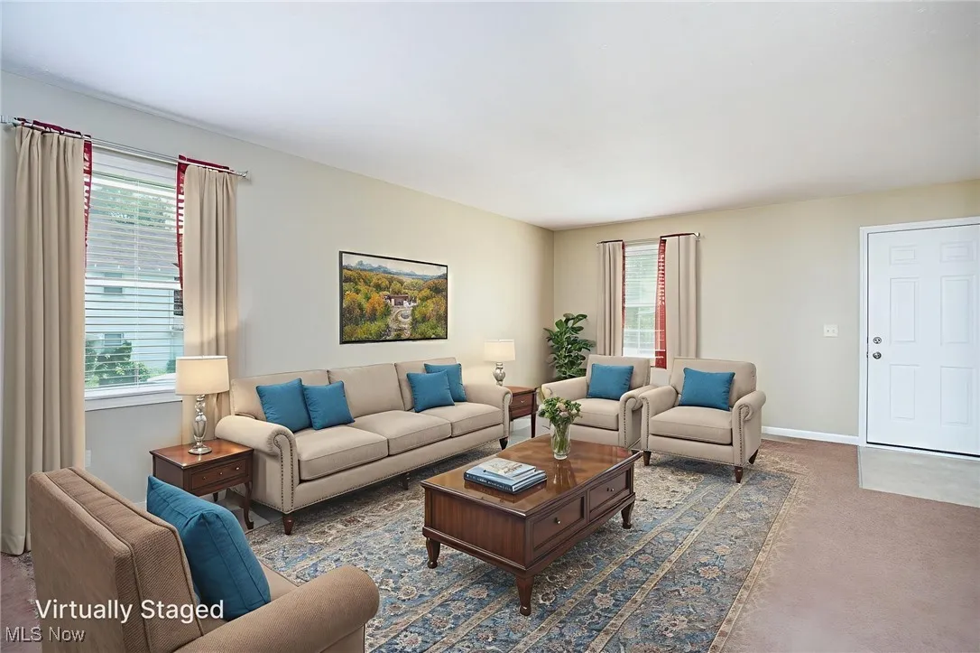 Carpeted living area featuring healthy amount of natural light