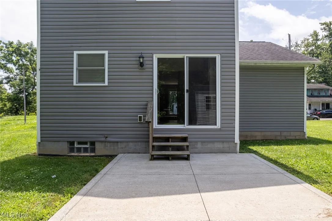 Entrance to property with a lawn and a patio