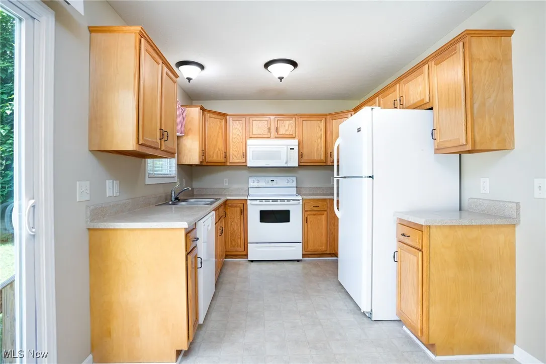 Kitchen featuring white appliances, light countertops, and light floors