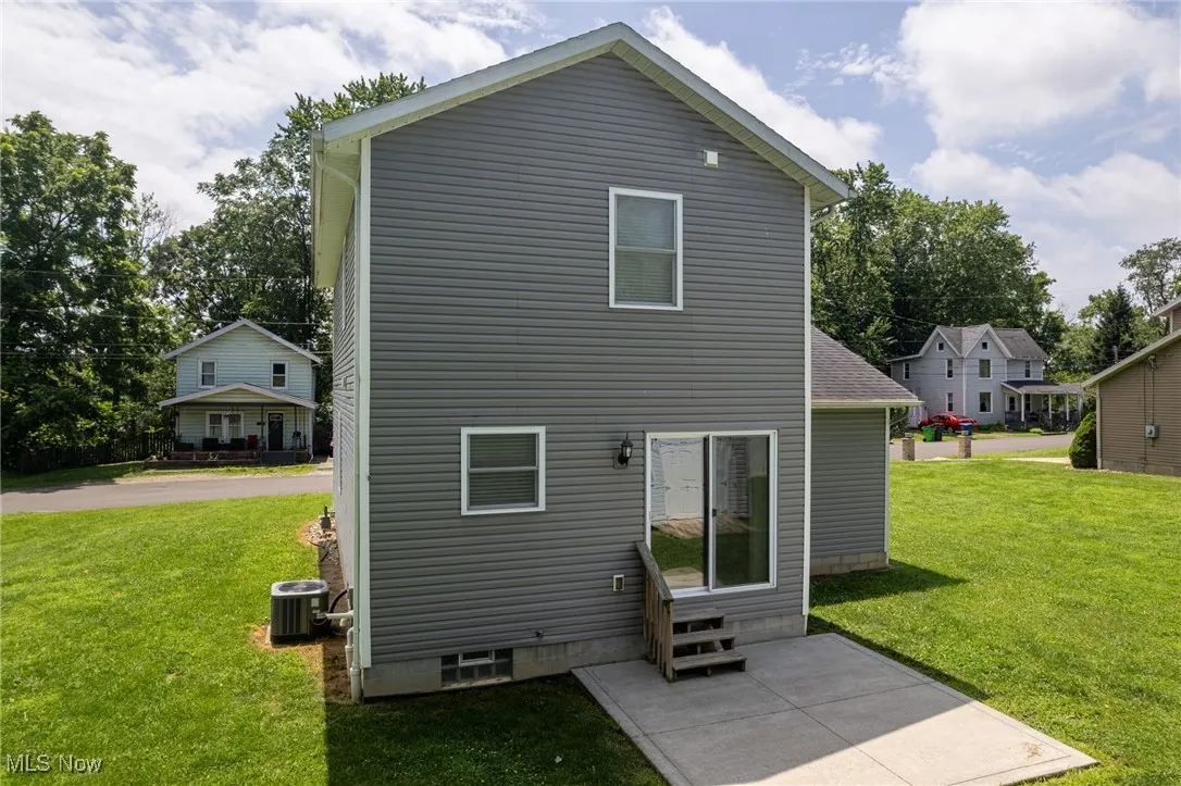 Back of house featuring entry steps and a lawn