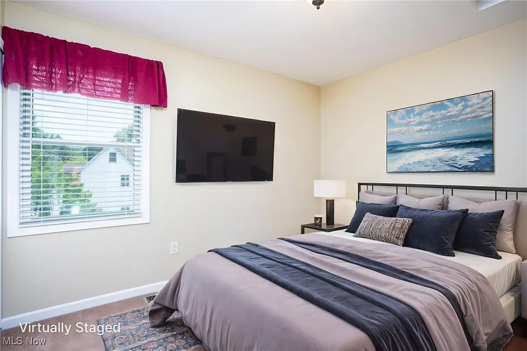 Bedroom featuring multiple windows and carpet