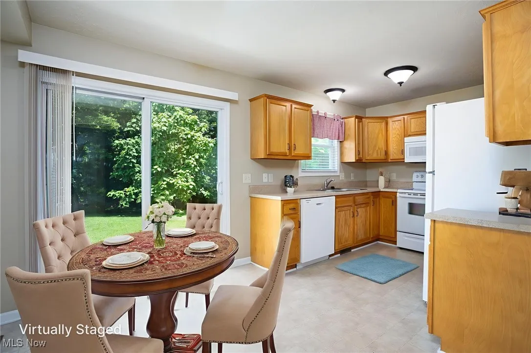 Kitchen featuring white appliances, light countertops, and plenty of natural light