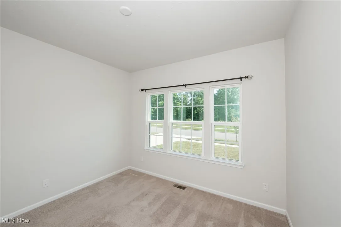 Carpeted spare room with baseboards
