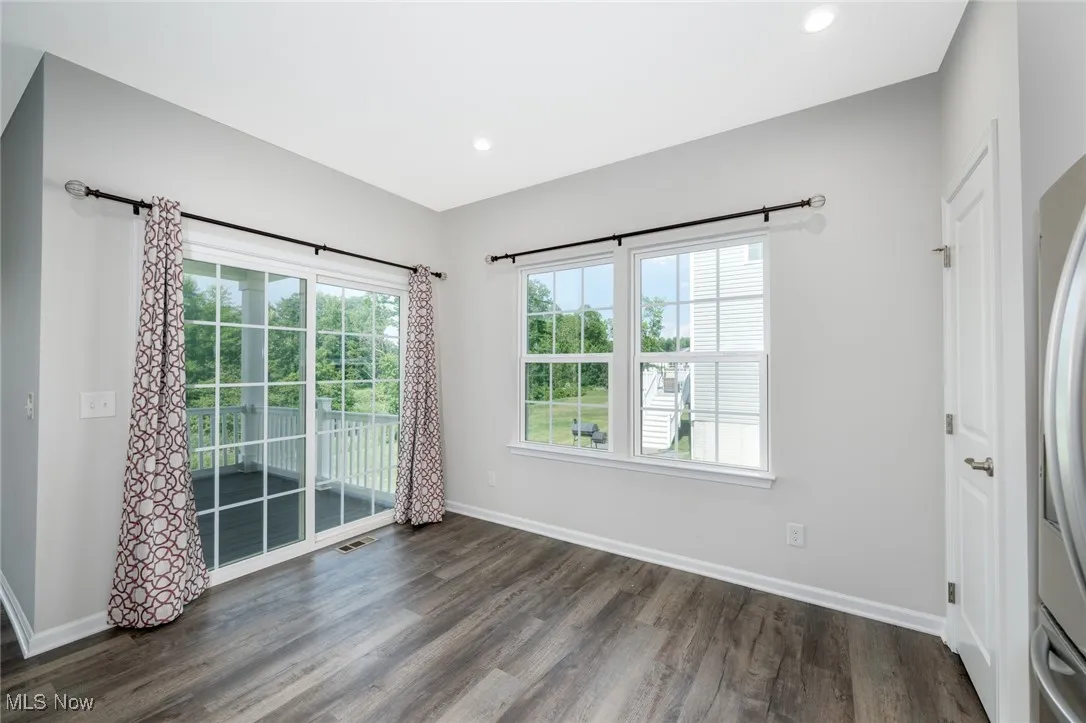 Empty room featuring dark wood-style flooring and recessed lighting