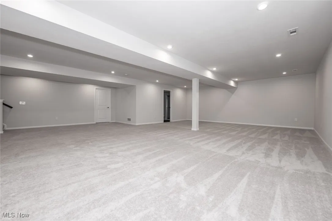 Finished below grade area featuring recessed lighting and light colored carpet