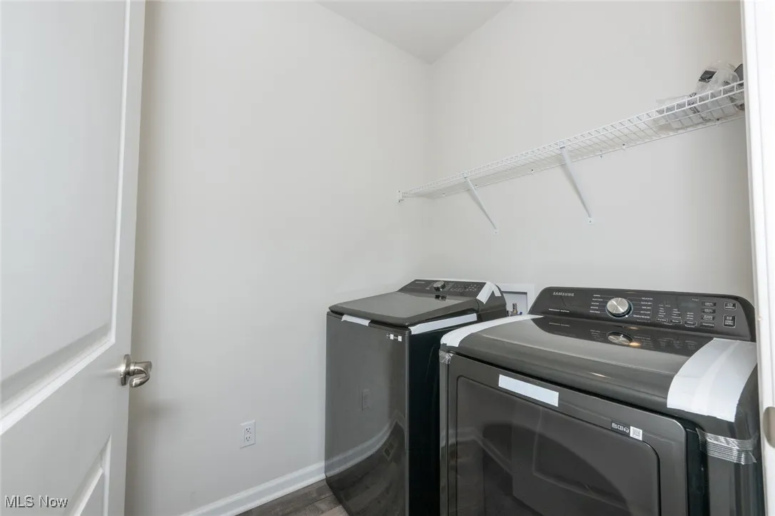 Washroom featuring washer and clothes dryer and wood finished floors