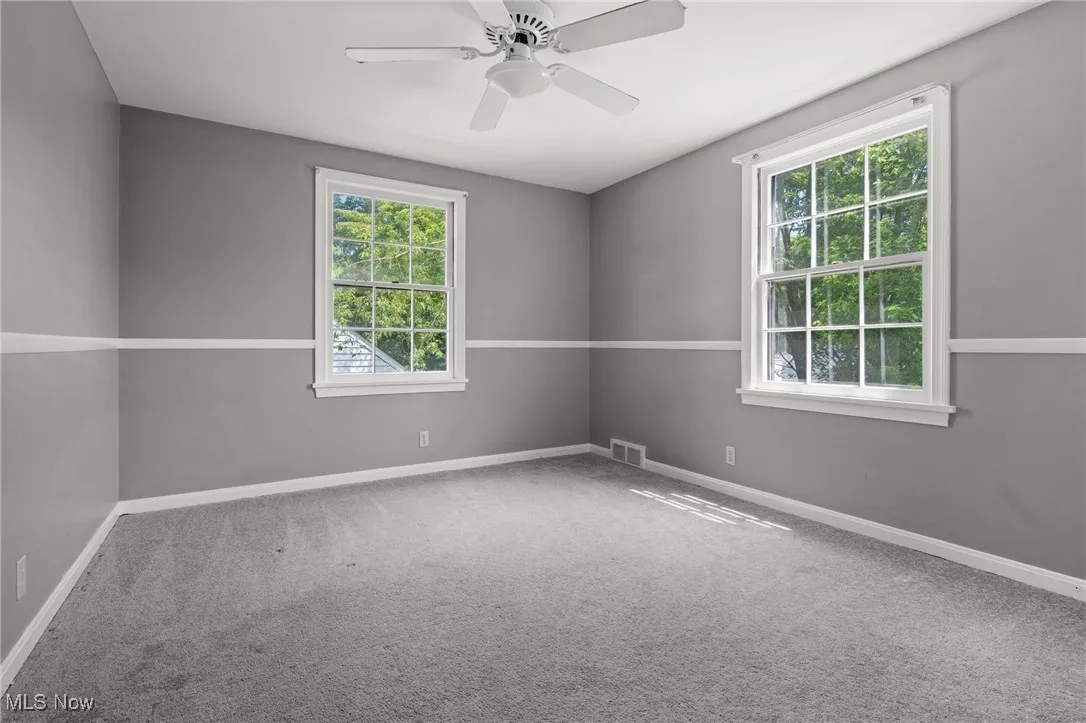 Spare room with carpet floors and a ceiling fan