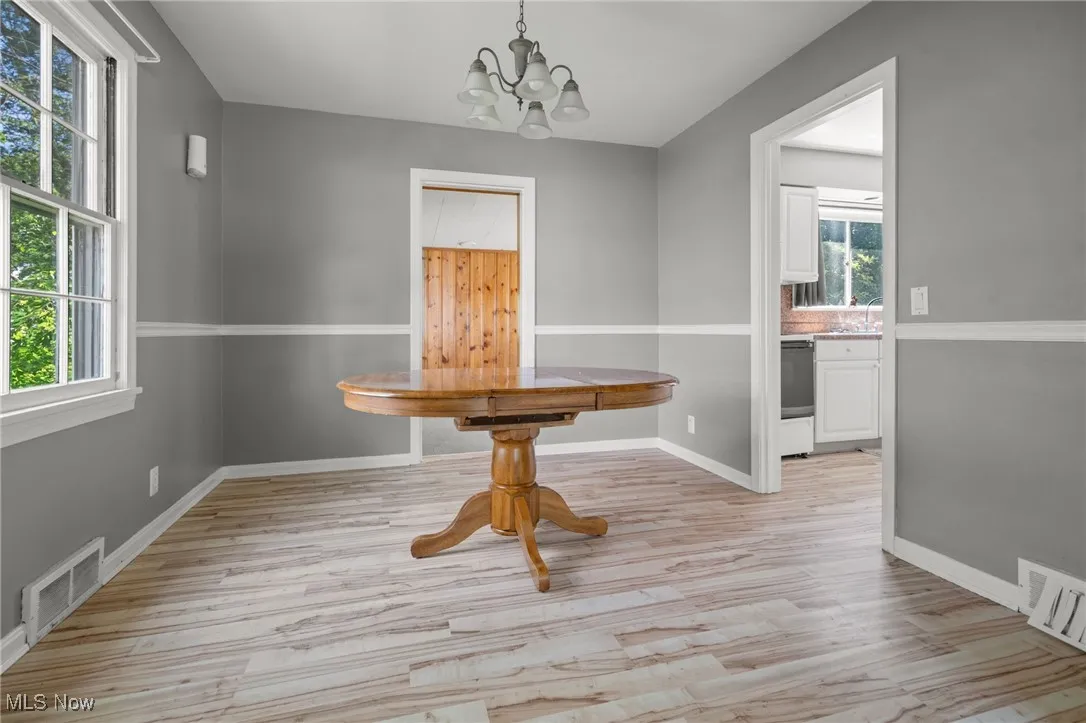 Unfurnished dining area featuring a chandelier and light wood finished floors