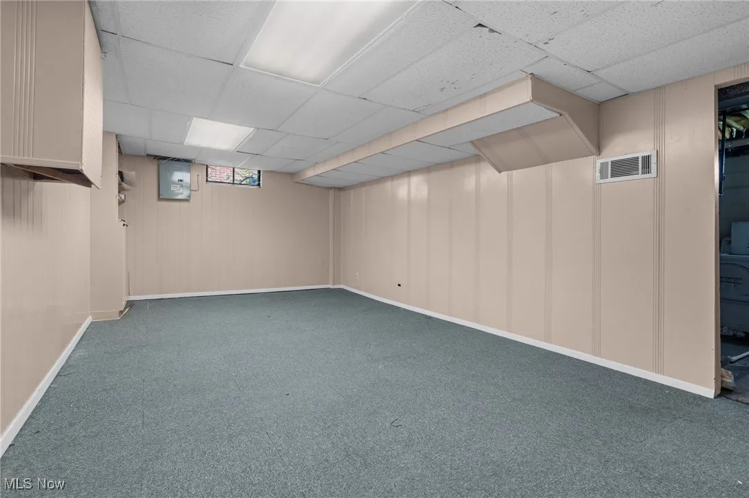 Below grade area with carpet floors and a drop ceiling