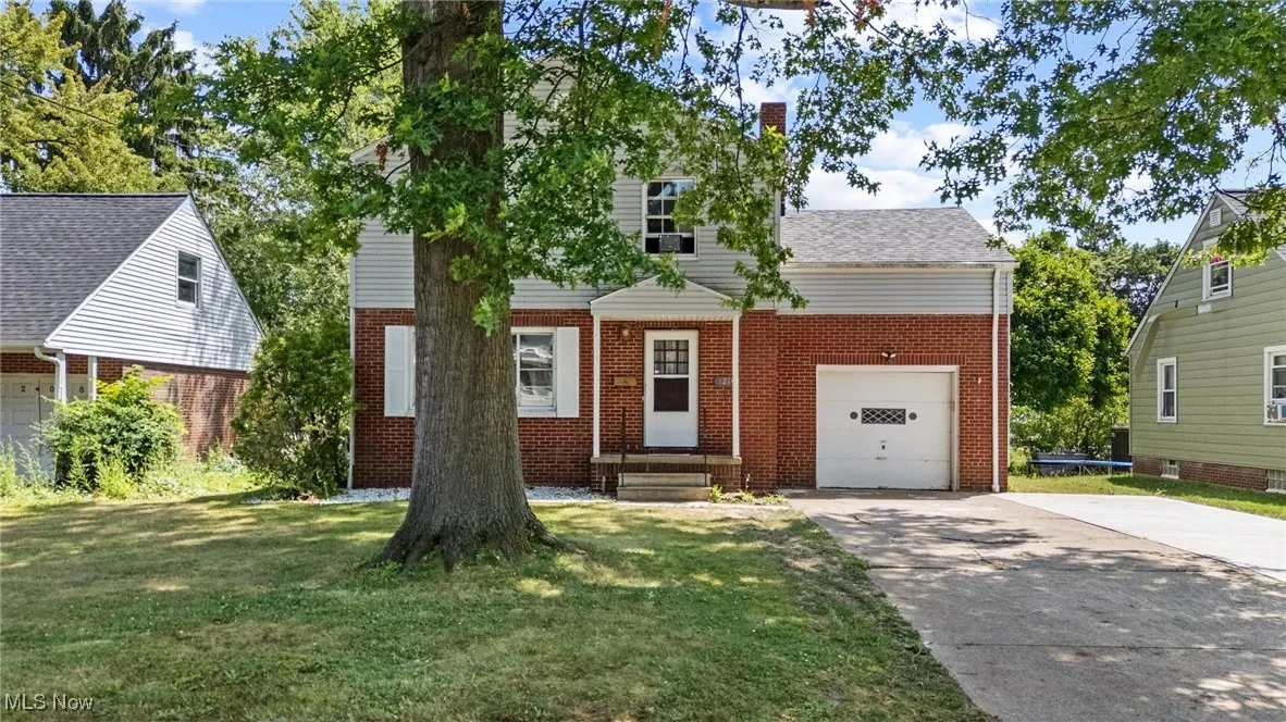 View of front of home featuring brick siding, a front lawn, driveway, and entry steps