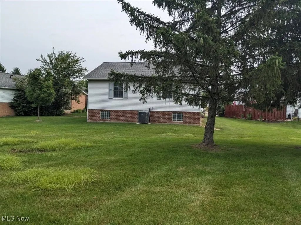 Rear view of property with a yard