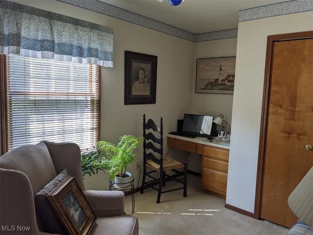 Home office with light carpet and baseboards