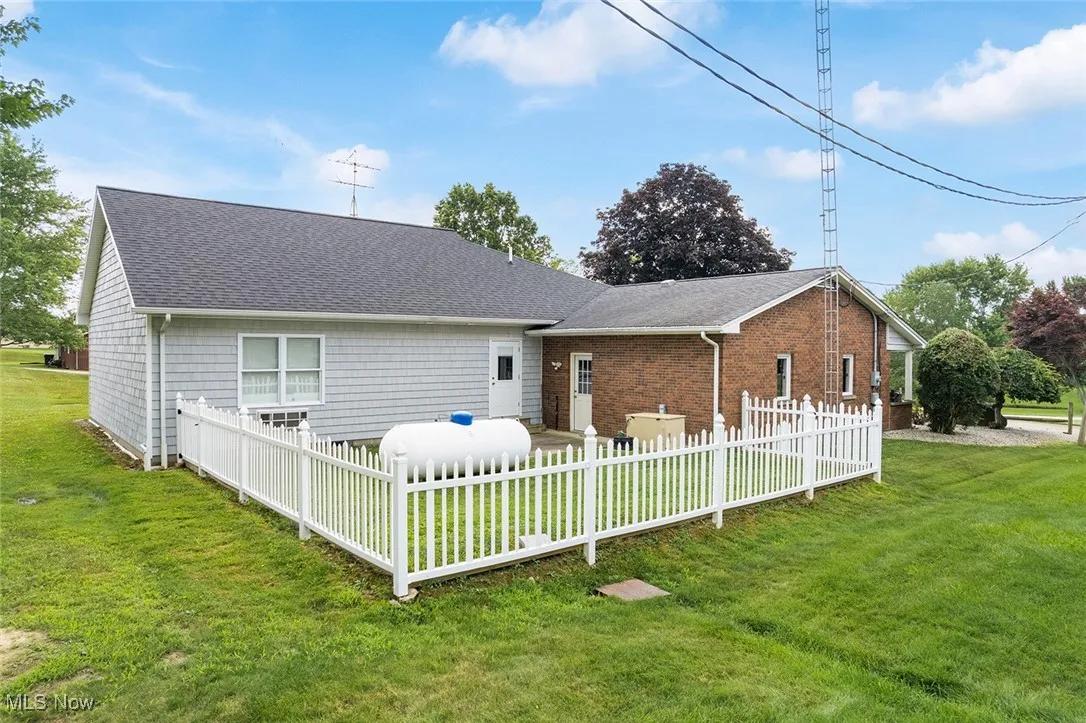 Rear view of property with roof with shingles and brick siding