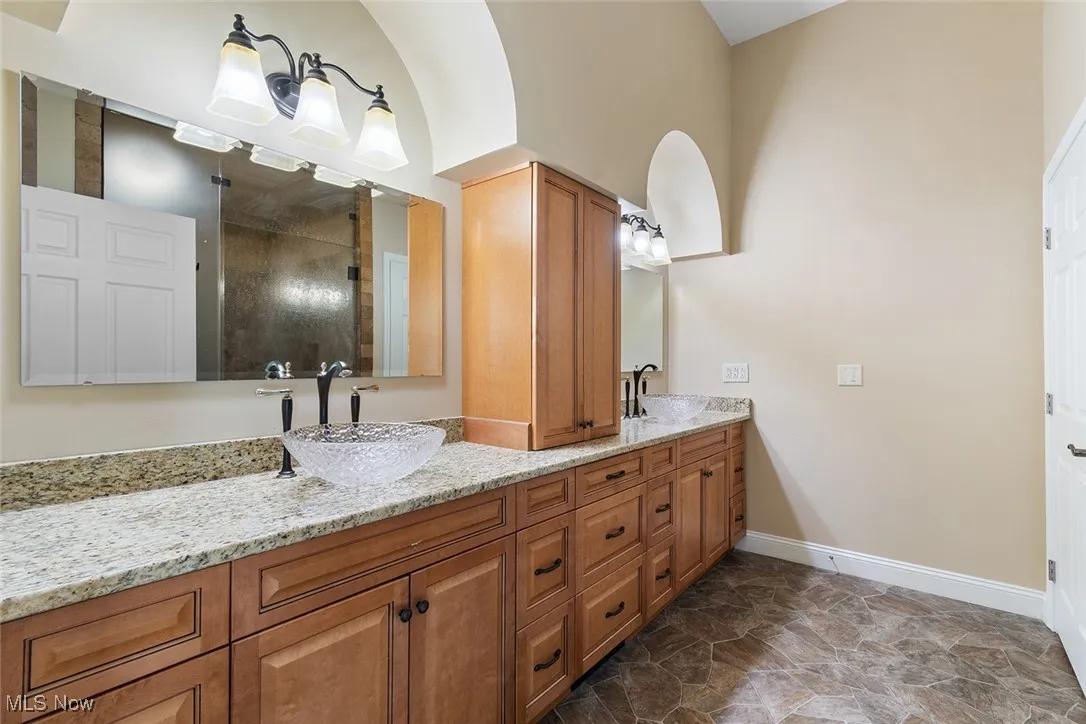 Bathroom featuring double vanity and tiled shower