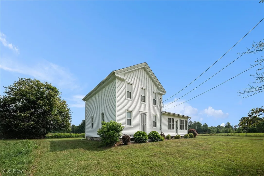 View of side of home with a lawn