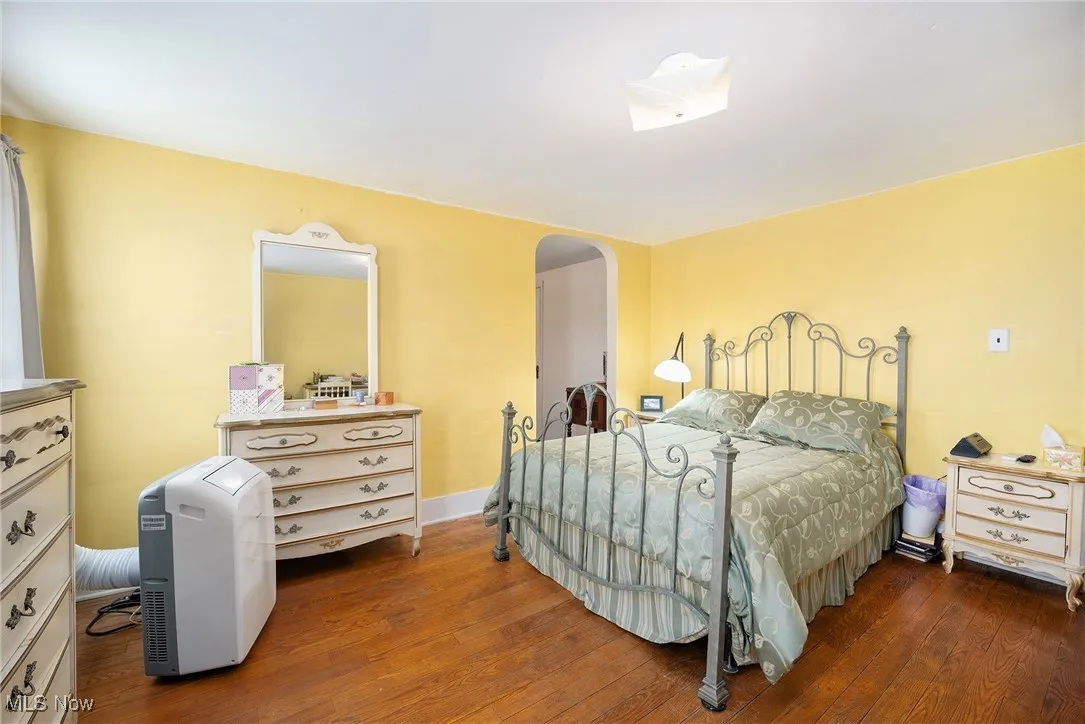 Bedroom featuring arched walkways and hardwood / wood-style floors