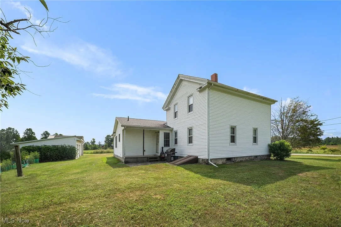 Rear view of property featuring a yard and a chimney