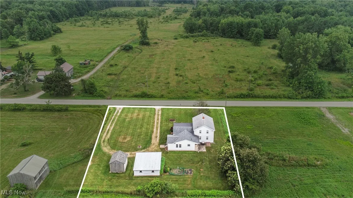 Aerial view of property and surrounding area featuring property boundaries highlighted and rural landscape