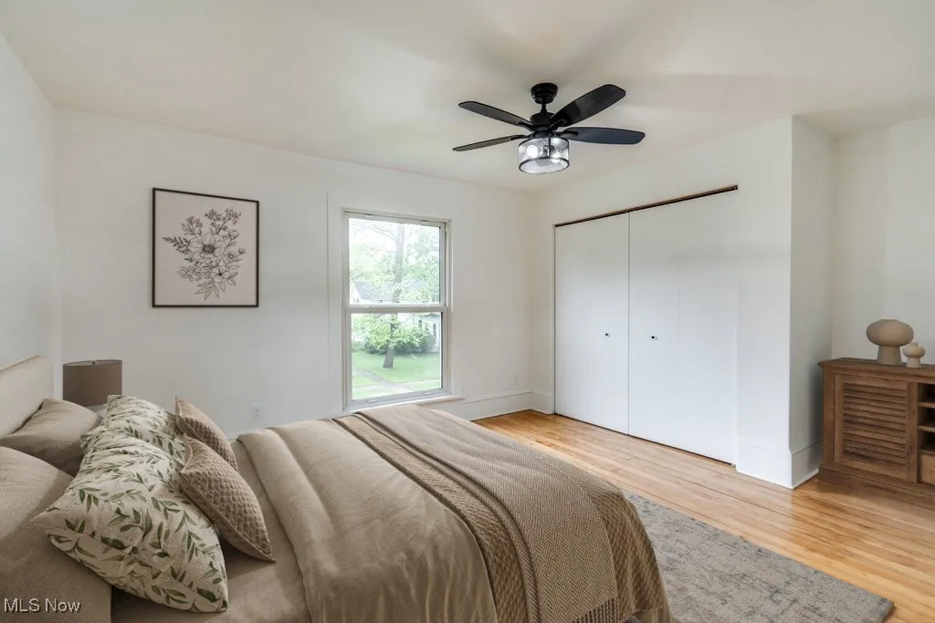 Bedroom featuring light wood-style floors, a closet, and a ceiling fan