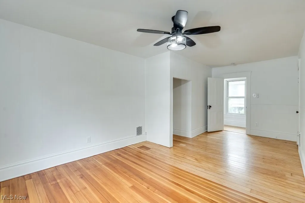 Empty room featuring ceiling fan and light wood-style floors