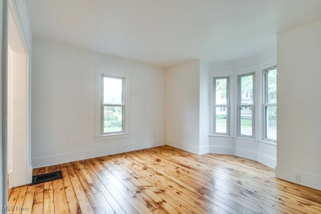 Unfurnished room with hardwood / wood-style flooring and baseboards