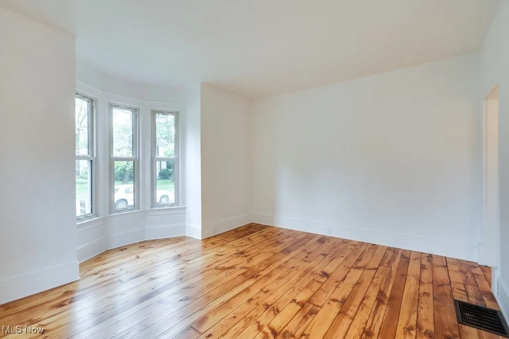 Unfurnished room featuring light wood finished floors and baseboards