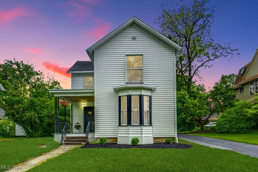 Traditional-style house featuring covered porch and a front lawn