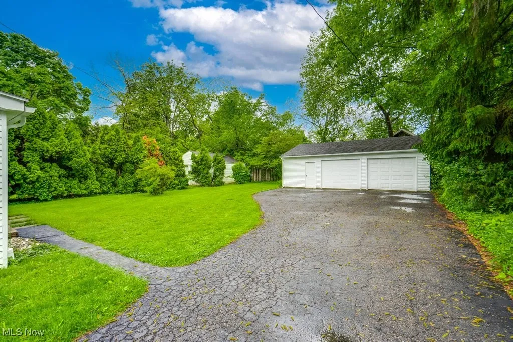 View of grassy yard featuring an outdoor structure and a garage