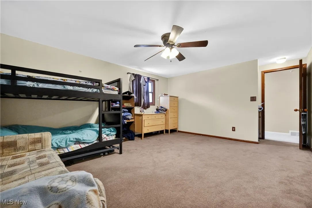 Carpeted bedroom with baseboards and a ceiling fan