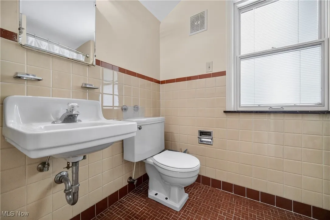 Bathroom with tile walls and toilet