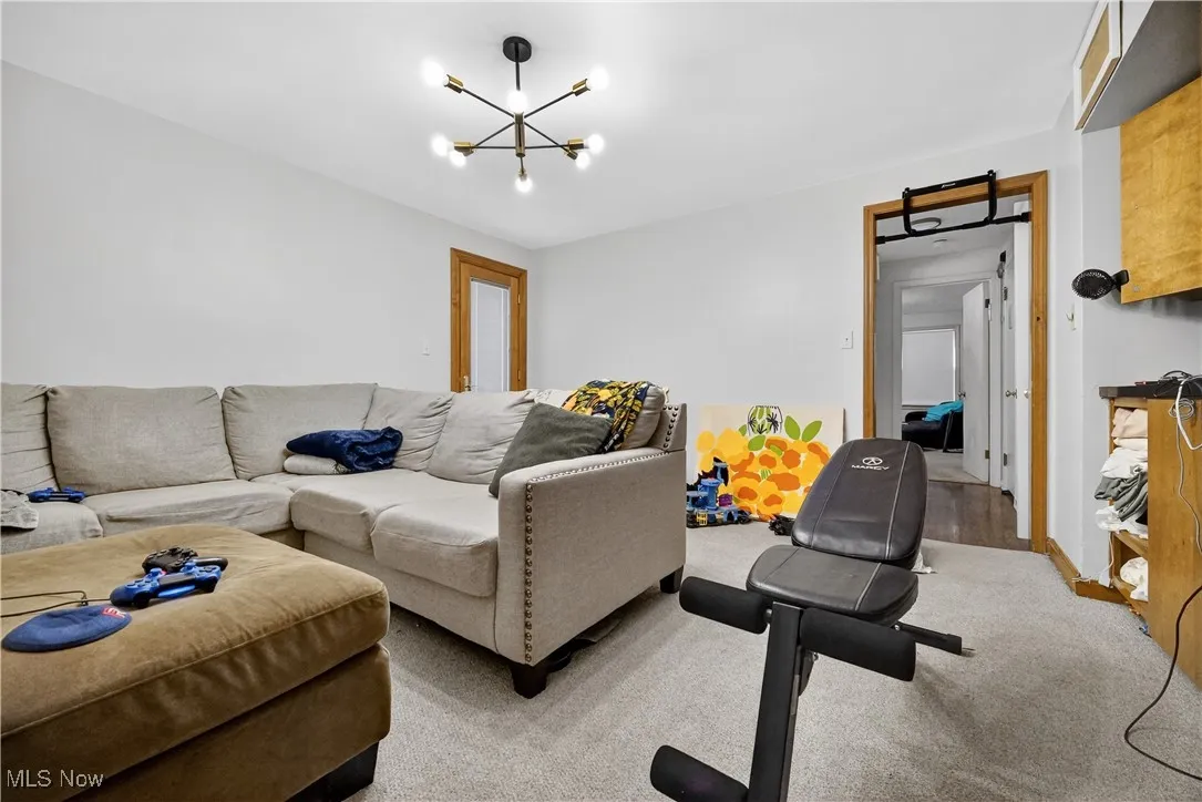 Living room with light colored carpet and a chandelier