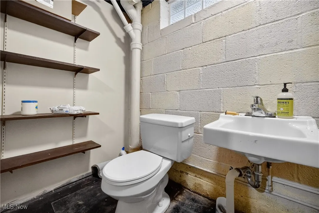 Bathroom with toilet and concrete block wall