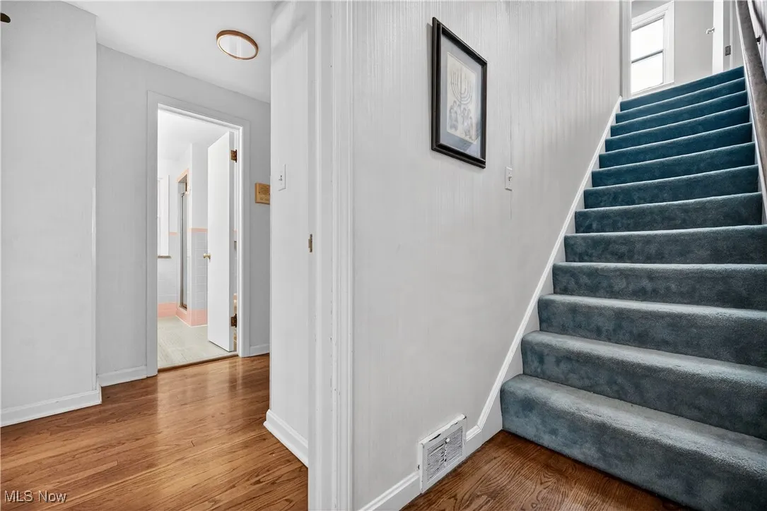 Staircase with wood finished floors and baseboards