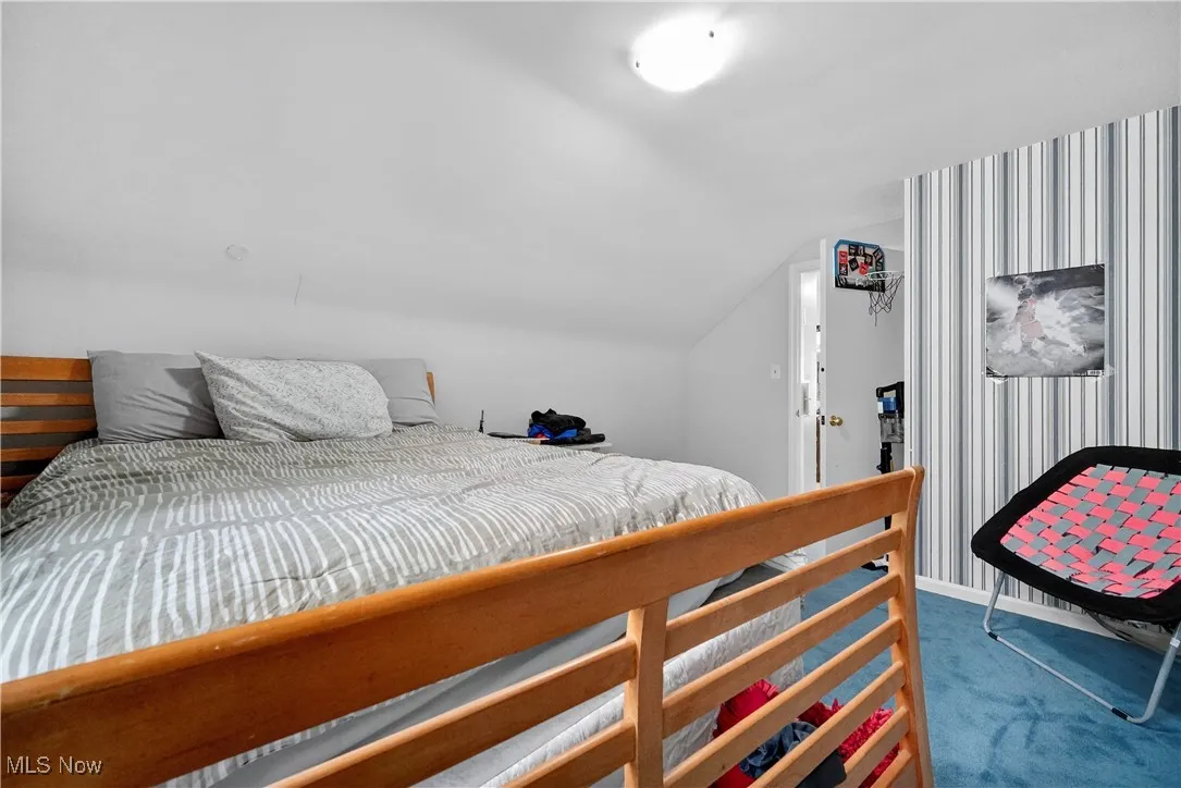 Bedroom with carpet floors and lofted ceiling