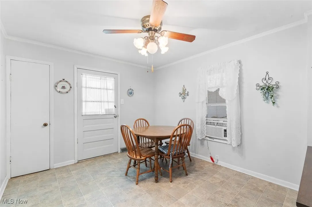 Dining area with ornamental molding, ceiling fan, and cooling unit