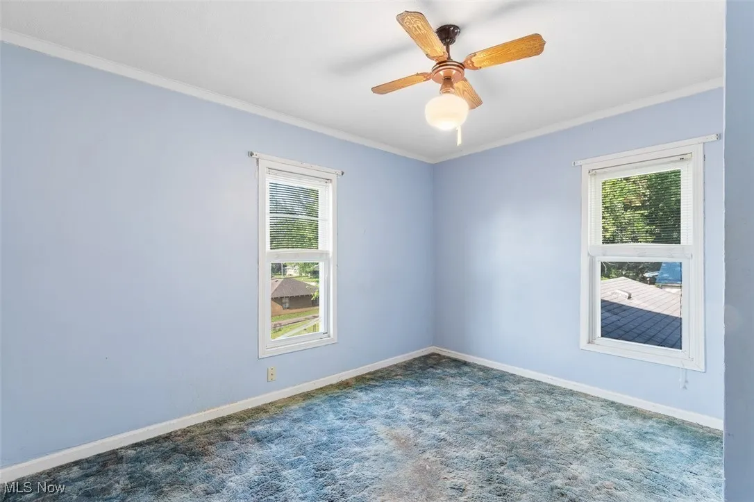 Bedroom featuring plenty of natural light, crown molding, carpet flooring, and ceiling fan