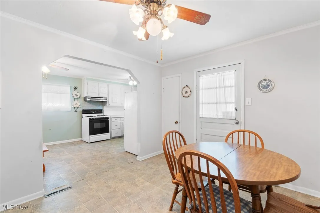 Dining space featuring ceiling fan and ornamental molding