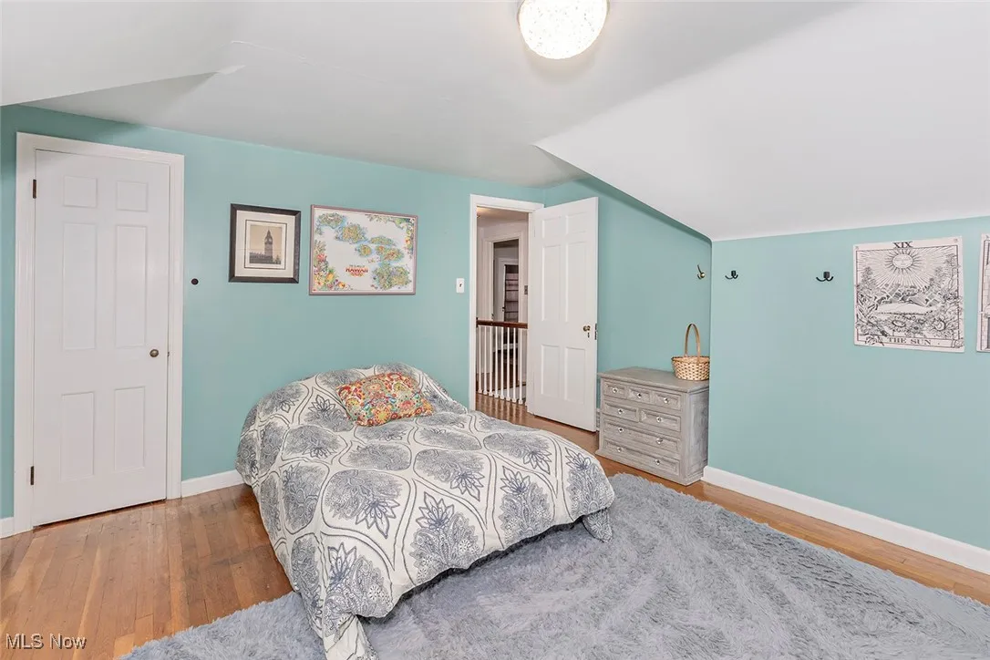 Bedroom featuring wood finished floors and lofted ceiling
