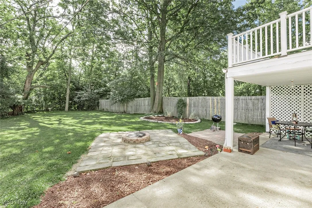 Fenced backyard featuring a fire pit and a patio area