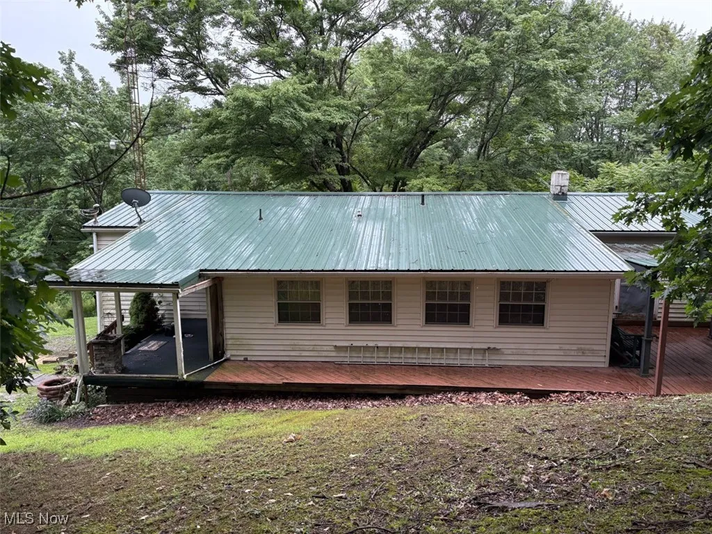 Front of property with a metal roof and a deck