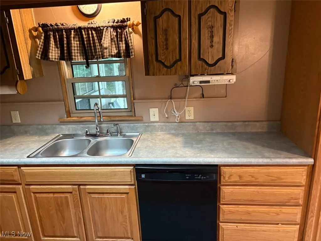 Kitchen featuring black dishwasher and light countertops