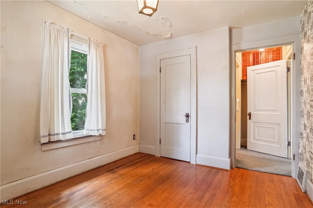 Unfurnished bedroom featuring baseboards and wood finished floors
