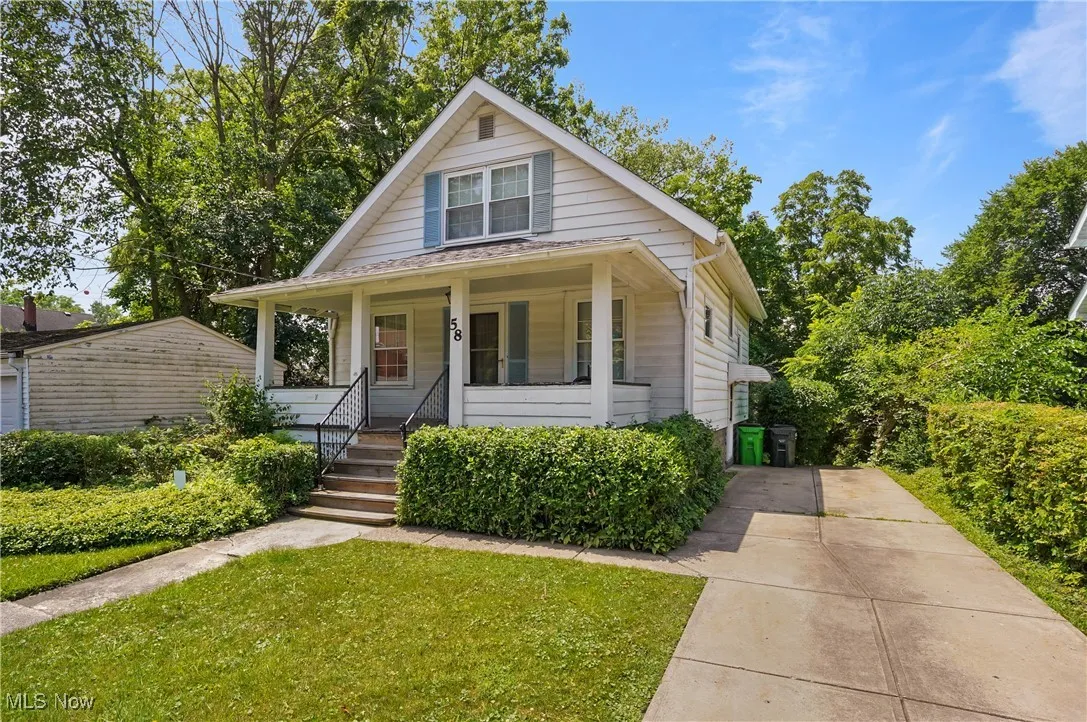 Bungalow featuring covered porch and a front yard