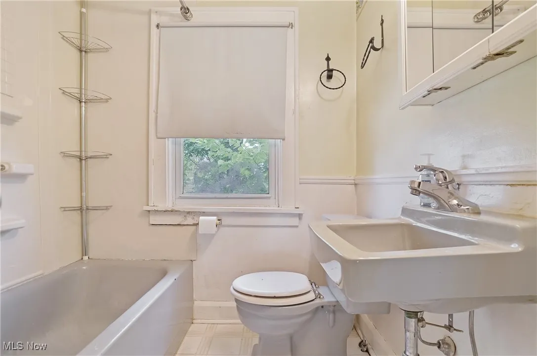 Full bath with baseboards and toilet