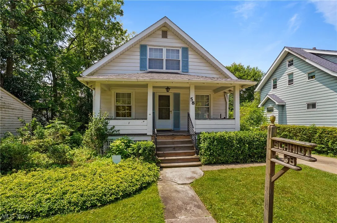Bungalow featuring a porch and a front lawn