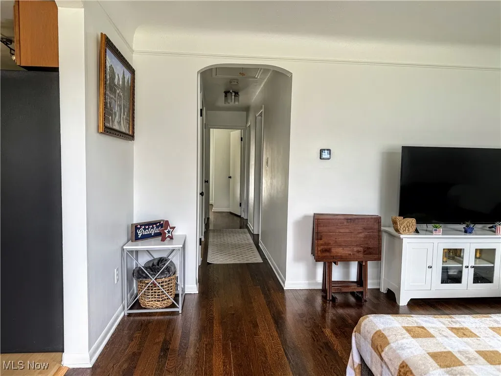 Hallway featuring wood finished floors and arched walkways