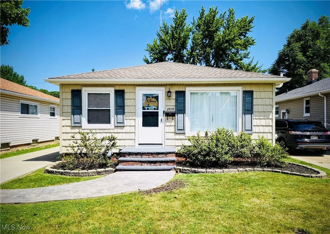 Bungalow-style house featuring a front lawn and roof with shingles
